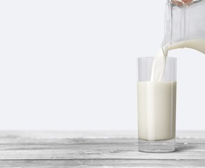 Canvas Print - A glass of milk and bottle on wooden desk