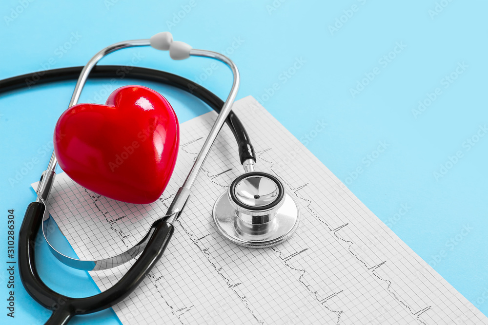 Stethoscope, red heart and cardiogram on color background. Cardiology concept