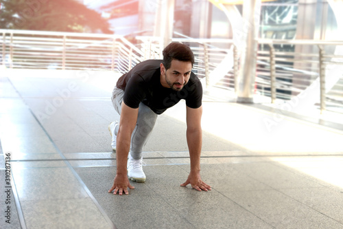 Cuadros en Lienzo Young runner man stretching body before exercise run outdoor, hansom male jogger