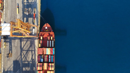 Aerial drone top down photo of industrial cargo container tanker ship carrier docked in commercial port terminal