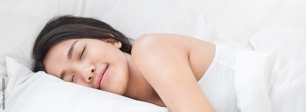 Portrait of beautiful young sexy asian woman with attractive smile enjoy fresh soft bedding linen mattress in white bed room modern apartment. Cute asia girl sleep resting, good night sleep banner - obrazy, fototapety, plakaty 