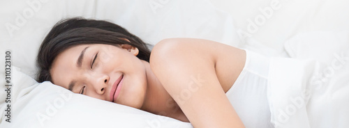 Fotomural Portrait of beautiful young sexy asian woman with attractive smile enjoy fresh soft bedding linen mattress in white bed room modern apartment