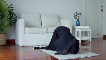 Wall Mural - Young Muslim female praying and practicing the Islamic faith