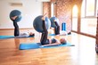 © Krakenimages.com - Young beautiful group of sportswomen practicing yoga. Stretching using fitness ball at gym