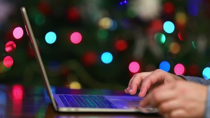 Wall Mural - Woman making online payment for holiday gifts, Christmas tree lights on background, 4k