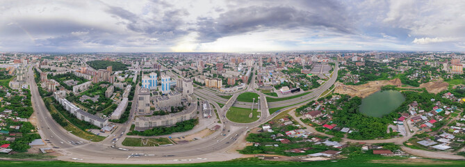 Wall Mural - Aerial view of the city with traffic, streets and buildings with green trees and rails under the blue sky with clouds at summer day in Novosibirsk. Panoramic 360 degrees of the planet.