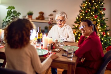 Wall Mural - Beautiful group of women smiling happy and confident. Eating roasted turkey celebrating christmas at home