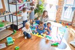 © Krakenimages.com - Beautiful teacher and group of toddlers playing around lots of toys at kindergarten