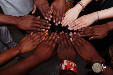 Wall Mural - Hands of happy group of multinational African, latin american and european people which stay together in circle