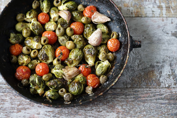 Brussels sprouts with vegetables and herbs in a pan. Cooking Brussels sprouts. Vega food. Selective focus.