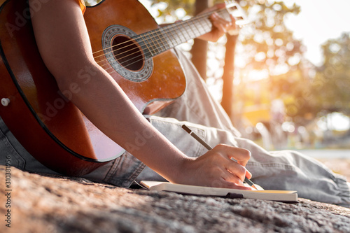Cuadros en Lienzo Songwriter writing on notebook with acoustic guitar.