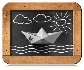 Wall Mural - Paper boat floating in the sea with clouds and sun, chalk drawing, in a blackboard with wooden frame. Isolated on white background, photography