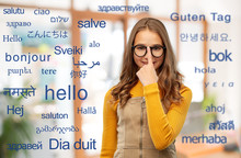 School, Education And Learning Concept - Smiling Teenage Student Girl In Glasses Over Greeting Words In Different Foreign Languages
