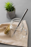 Fototapeta Sypialnia - eco friendly concept - empty glass mug of with reusable metallic straw