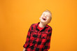 © Robert Przybysz - Great joy, a laughing child.. Young handsome smiling caucasian boy in the red shirt on the yellow background. Horizontal, straight on.