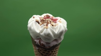 Wall Mural - Close-up of ice cream  melting on green background, time lapse