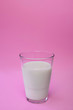 glass of milk on a pink background