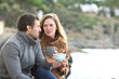 © Antonioguillem - Serious couple of adults talking in winter on the beach