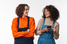 Portrait Of Joyful Multinational Women Laughing And Using Cellphone