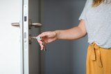 Woman hands opening a door with keys. Close up. Hand unlocks key lock door. Coming back home.