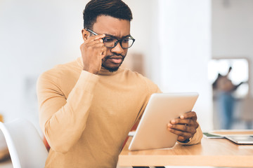 Poster - Serious afro manager using his touchpad to read email