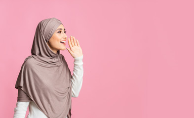 Wall Mural - Muslim girl in hijab shouting at copy space, making announcement