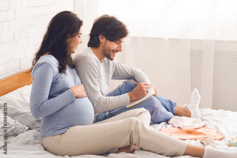 Expecting couple writing checklist before going to maternity hospital - obrazy, fototapety, plakaty 