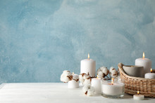 Burning Candles, Basket And Cotton On White Wooden Table, Space For Text