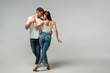 Dancers In Denim Jeans Dancing Bachata On Grey Background