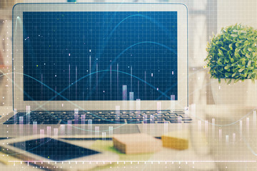 Financial chart drawing and table with computer on background. Multi exposure. Concept of international markets.