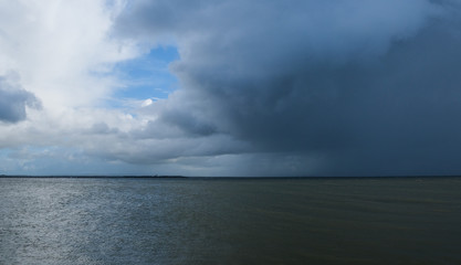 Rain cloud and rain fall over the water of Galway bay, taken on a summer day from Salthill Promenade, Ireland.