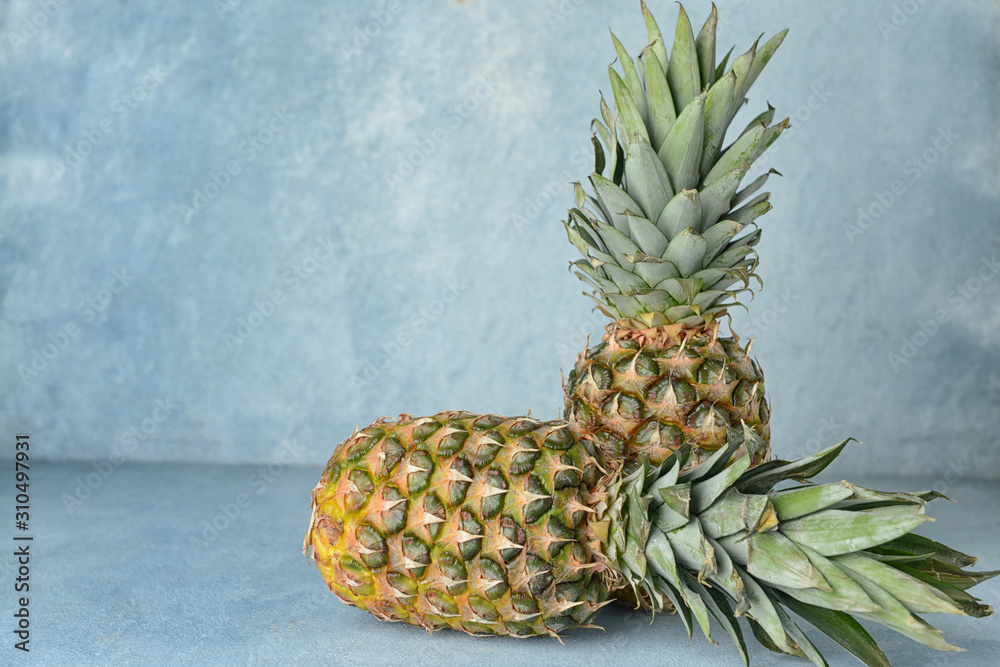 Fresh ripe pineapples on color background