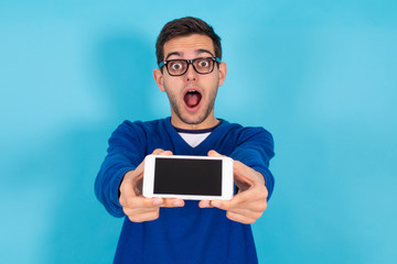 casual young hipster man with mobile phone isolated on color background