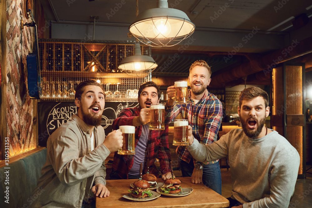 A group of guys watching sports on tv in a pub bar. - obrazy, fototapety, plakaty 