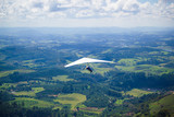 Hang glider in the blue sky. The sportsman flying on a hang glider