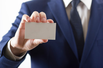 Hand holding white business card on white background