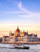The Hungarian Parliament Building Located On The Danube River In Budapest Hungary At Sunset.