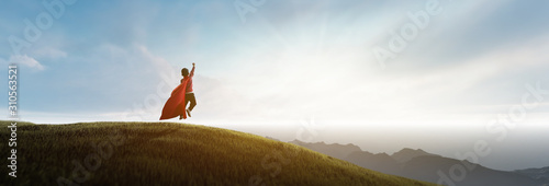 Fotomural Boy jumping and dreaming of being a superhero on the mountain