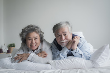 Wall Mural - elderly couple caucasian senior man and woman sleep on bed and smiling in white blanket in bedroom, retirement health care with love lifestyle concept