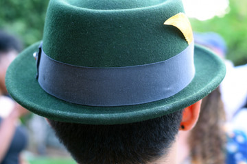 Close up of the back of the head of a man wearing a green hat