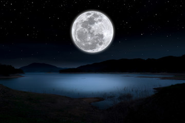 Wall Mural - Super full moon over lake in the dark night.