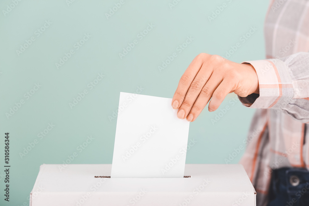 Voting woman near ballot box on color background