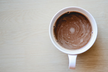 Coffee cup top view on wooden table background.