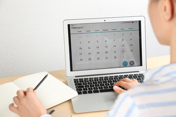 Poster - Woman using calendar app on laptop in office, closeup