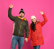 © New Africa - Happy young couple in warm clothes on pink background. Winter vacation