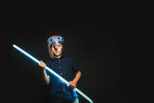 A Kid With A Light Saber In His Hands Play In A Superhero Battle.