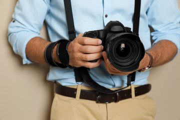 Professional photographer working on beige background in studio, closeup