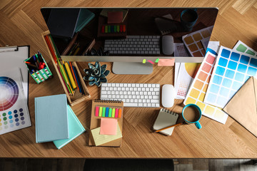 Poster - Designer's workplace with modern computer and color palettes, flat lay