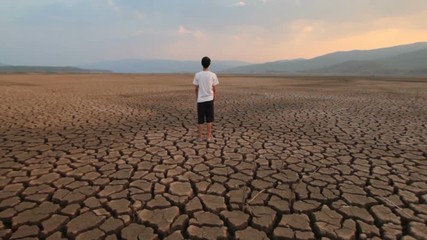 Sticker - Children and Climate change. Asian Young man standing at middle dry lake metaphor Water crisis, Drought and Global warming