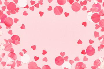 Wall Mural - Festive frame of red hearts confetti on pink pastel background love Valentine's Day.